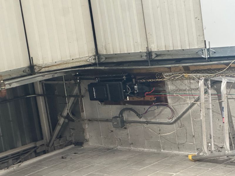 LiftMaster commercial chain drive opener with spring system close-up during service — MA