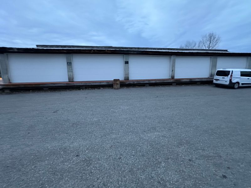 Multi-bay commercial storage facility with white garage doors — wide view in MA