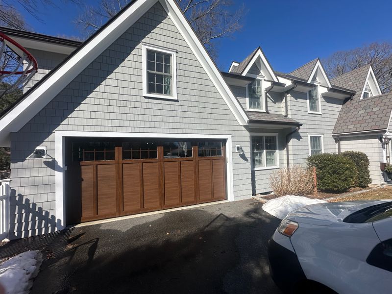 Wide view of craftsman wood garage door on gray colonial home in Massachusetts